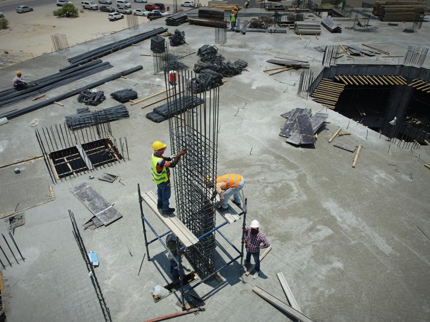 Crew tying rebar columns on a concrete slab