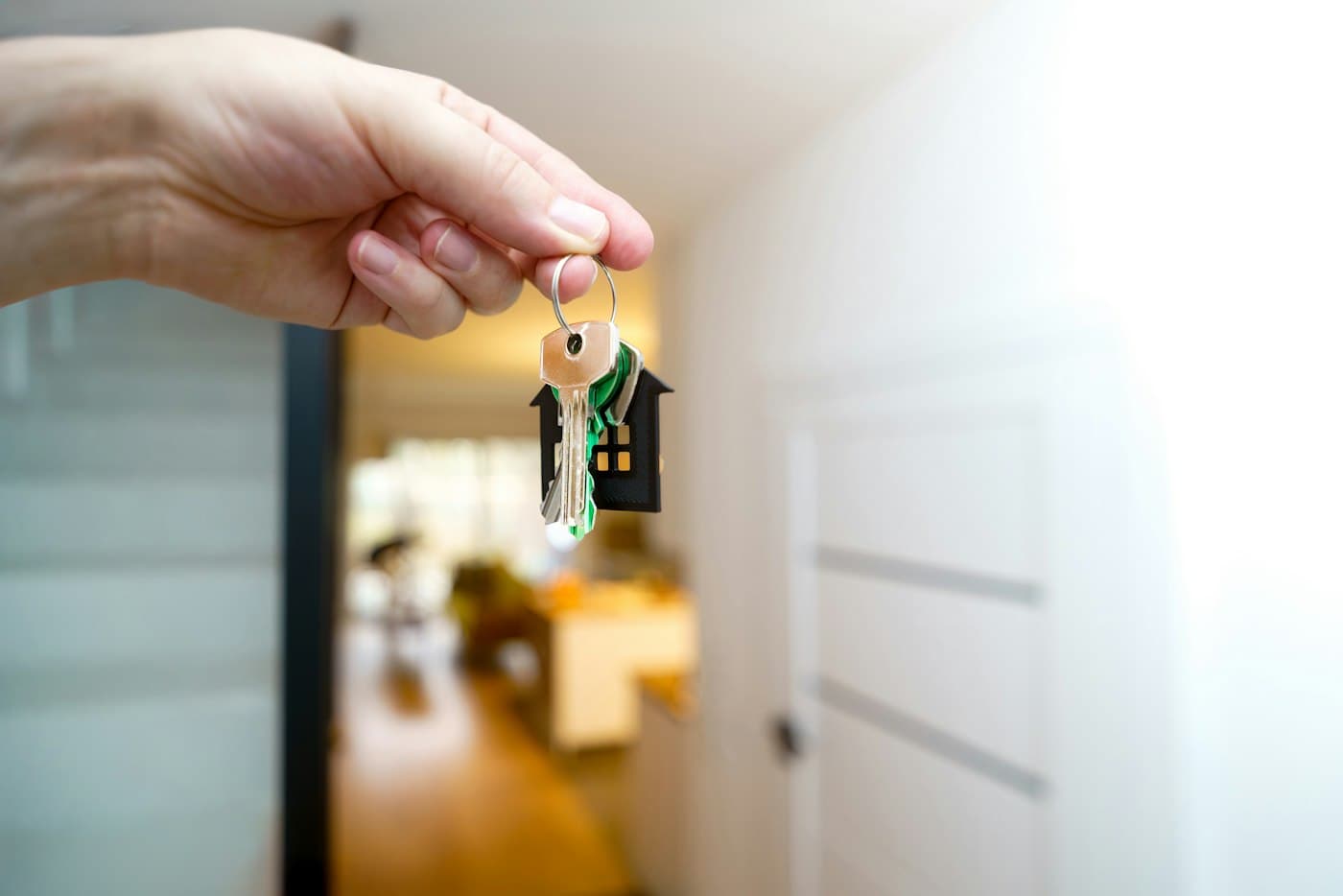 Hand holding a set of house keys indoors